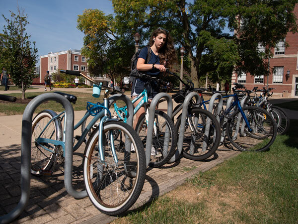 A student parks their bike in a bike rack.