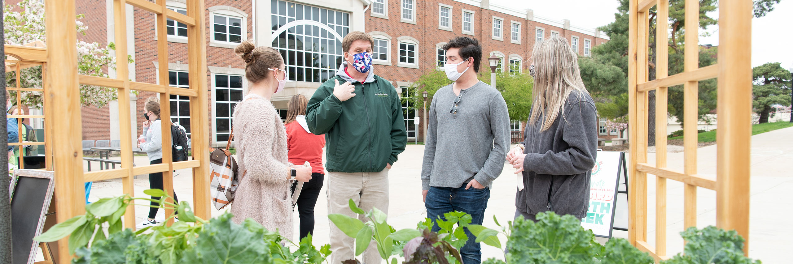 Students talking over an herb garden.