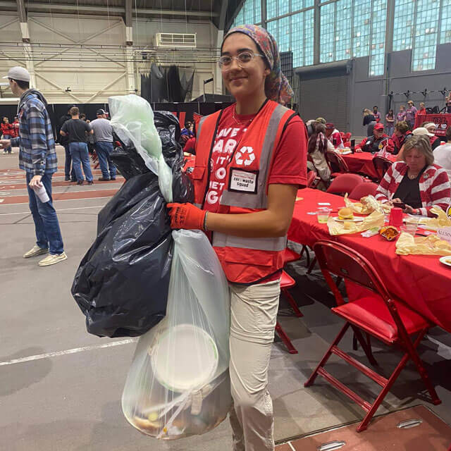 A person collects trash and recycling at a Zero Waste Event.