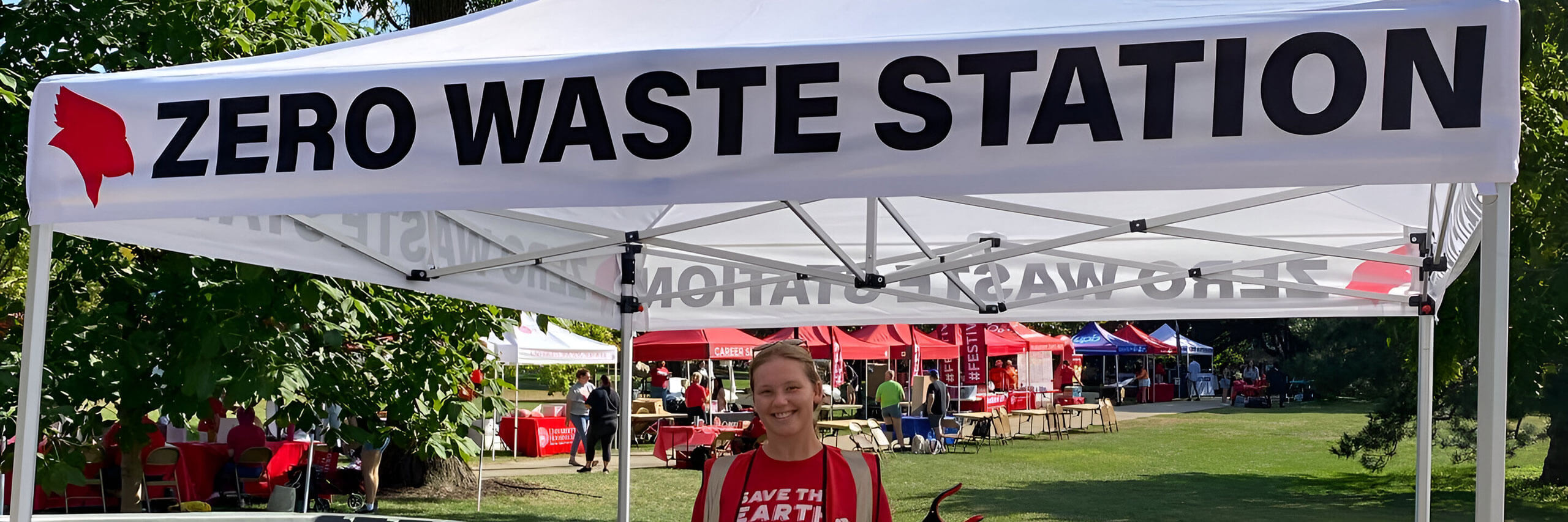 Student poses for photo at a Zero Waste Station on the quad.