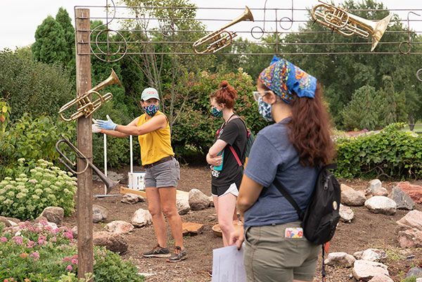 An instructor teaches students about the garden they are standing in.