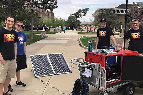 Students demonstrate how a solar panel and a wind turbine work.