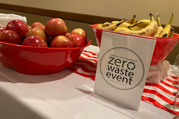 A Zero Waste Event sign sits next to some fruits