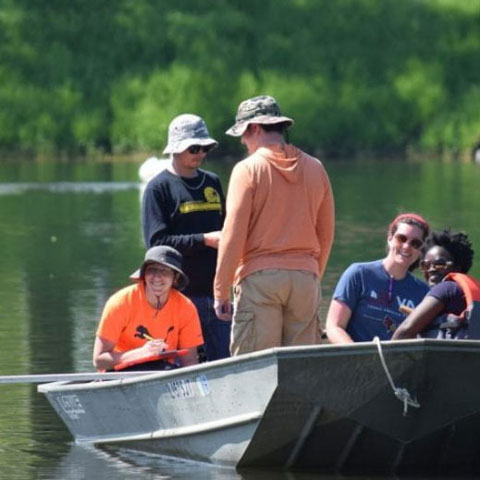 Students in a small boat doing research