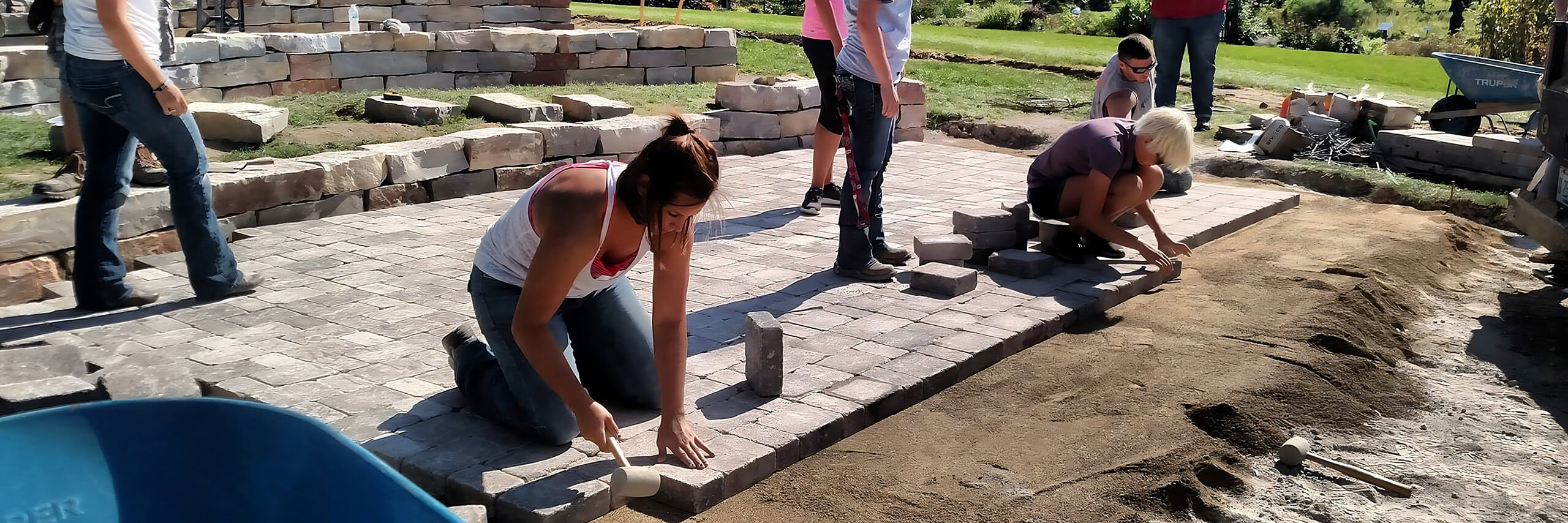 Students work on paving bricks.